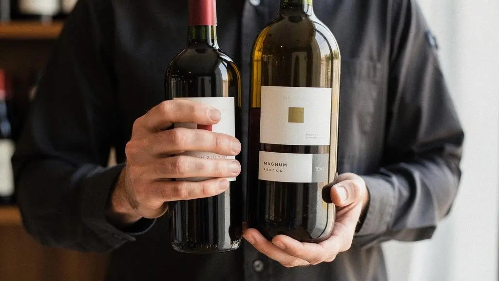 Professional hands comparing standard wine bottle and magnum bottle formats to illustrate capacity differences